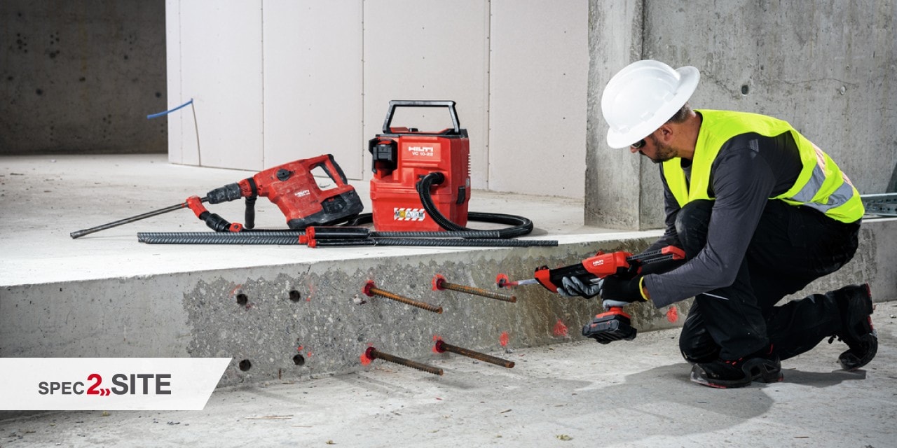 a worker uses a cordless driver to install a firestop device to a wall