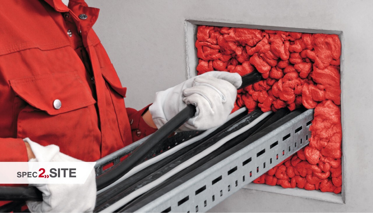 Employee applying fire protection foam at the jobsite.