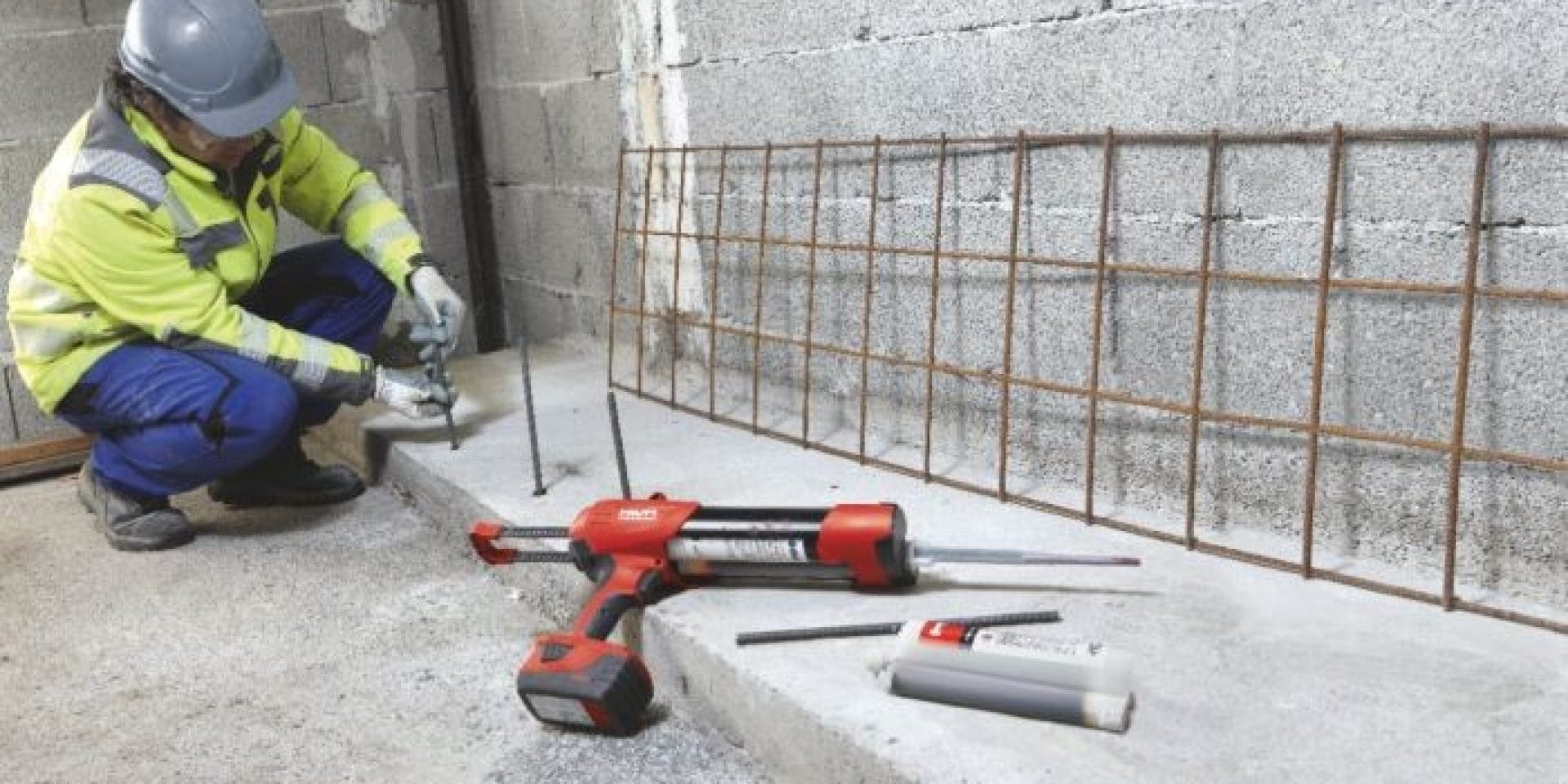 Jobsite worker inserting rebar into hole filled with Hilti Re 10 chemical mortar