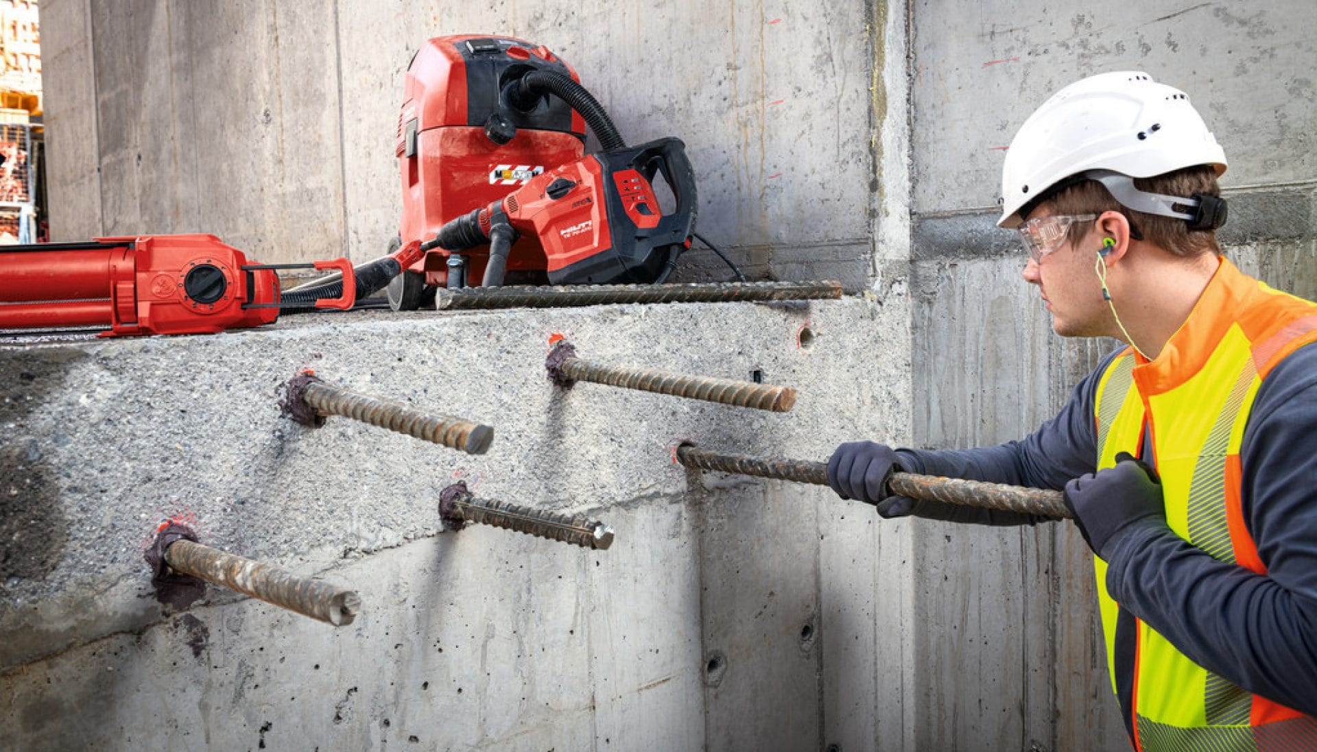 Jobsite person inserting rebar into holes filled with Hilti rebaring chemical 